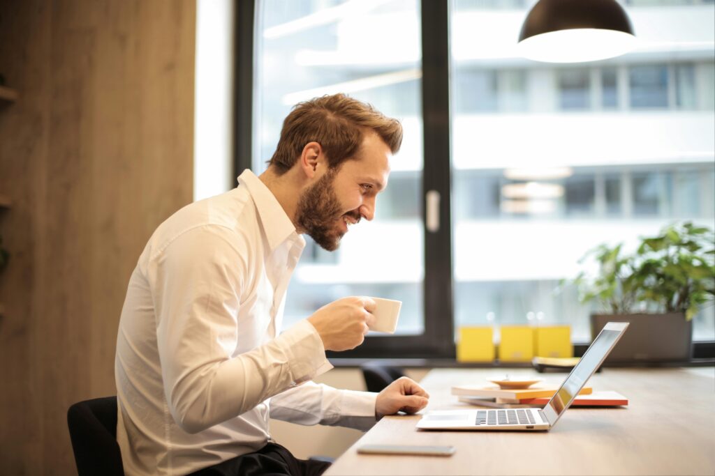 pexels-photo-925786-925786 Man Holding Teacup Infront of Laptop on Top of Table Inside the Room
